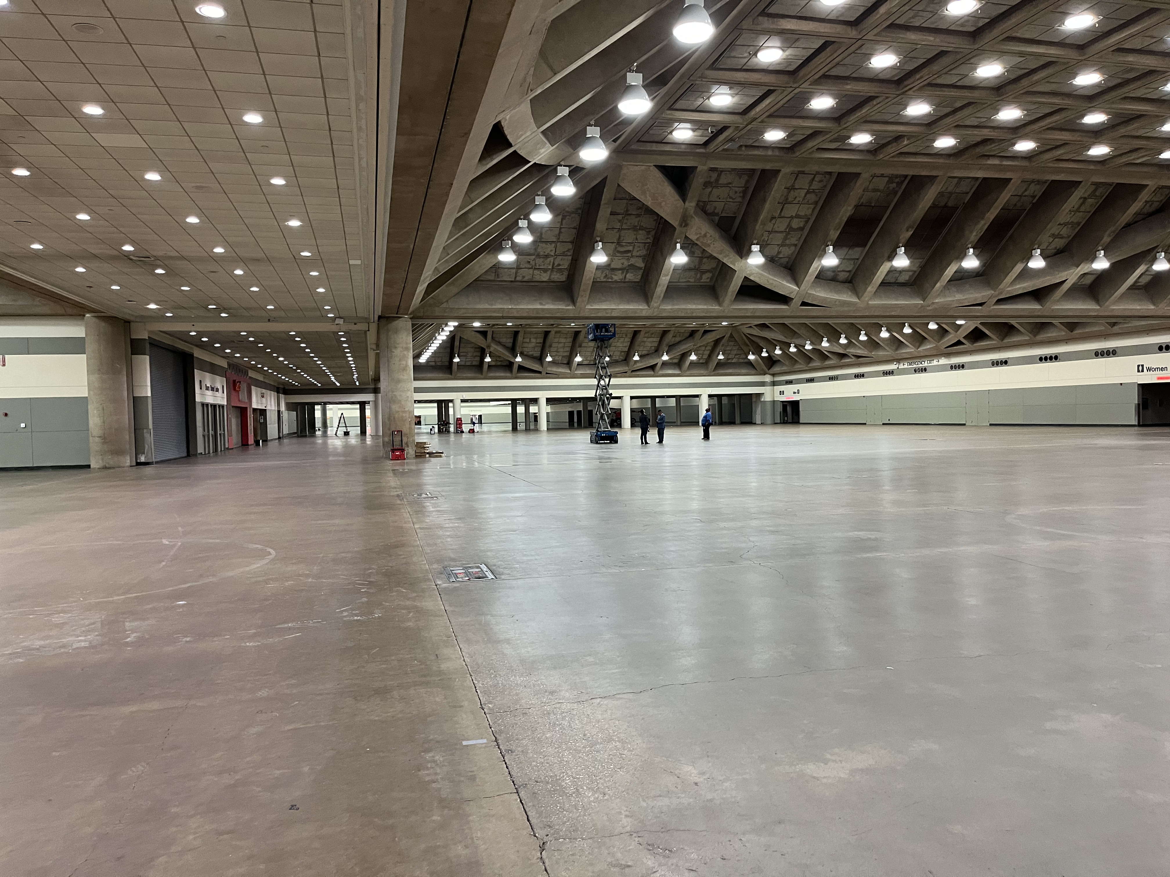 A photo of the exhibit halls, showing the overhead lighting and concrete flooring