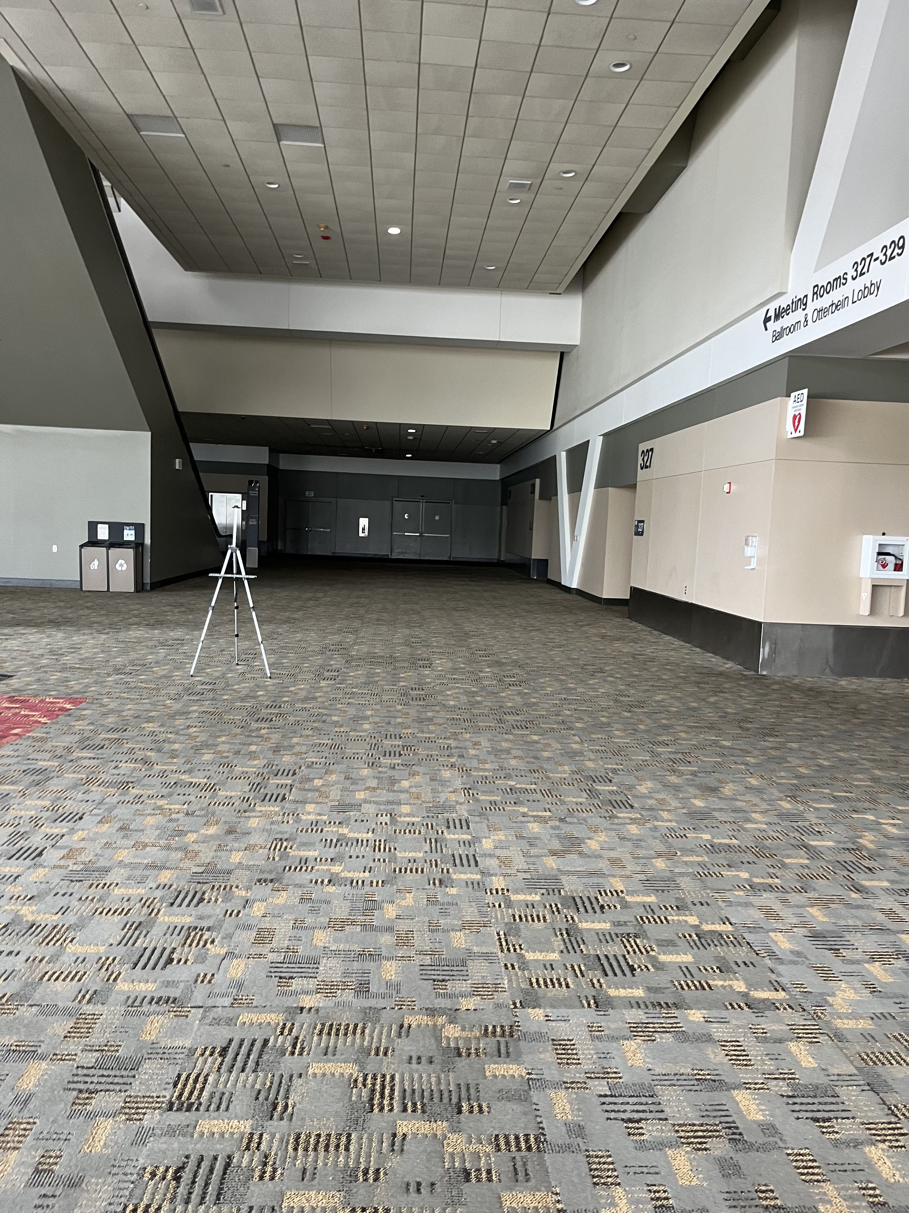 A photo of a hallway with rooms 327-329 on the right and an escalator and elevator to Level 400 on the left.